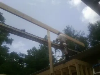 Carpenter setting a ridge beam over a new addition frame — Ice Dam Removal by Roofing Brothers in Evangeline