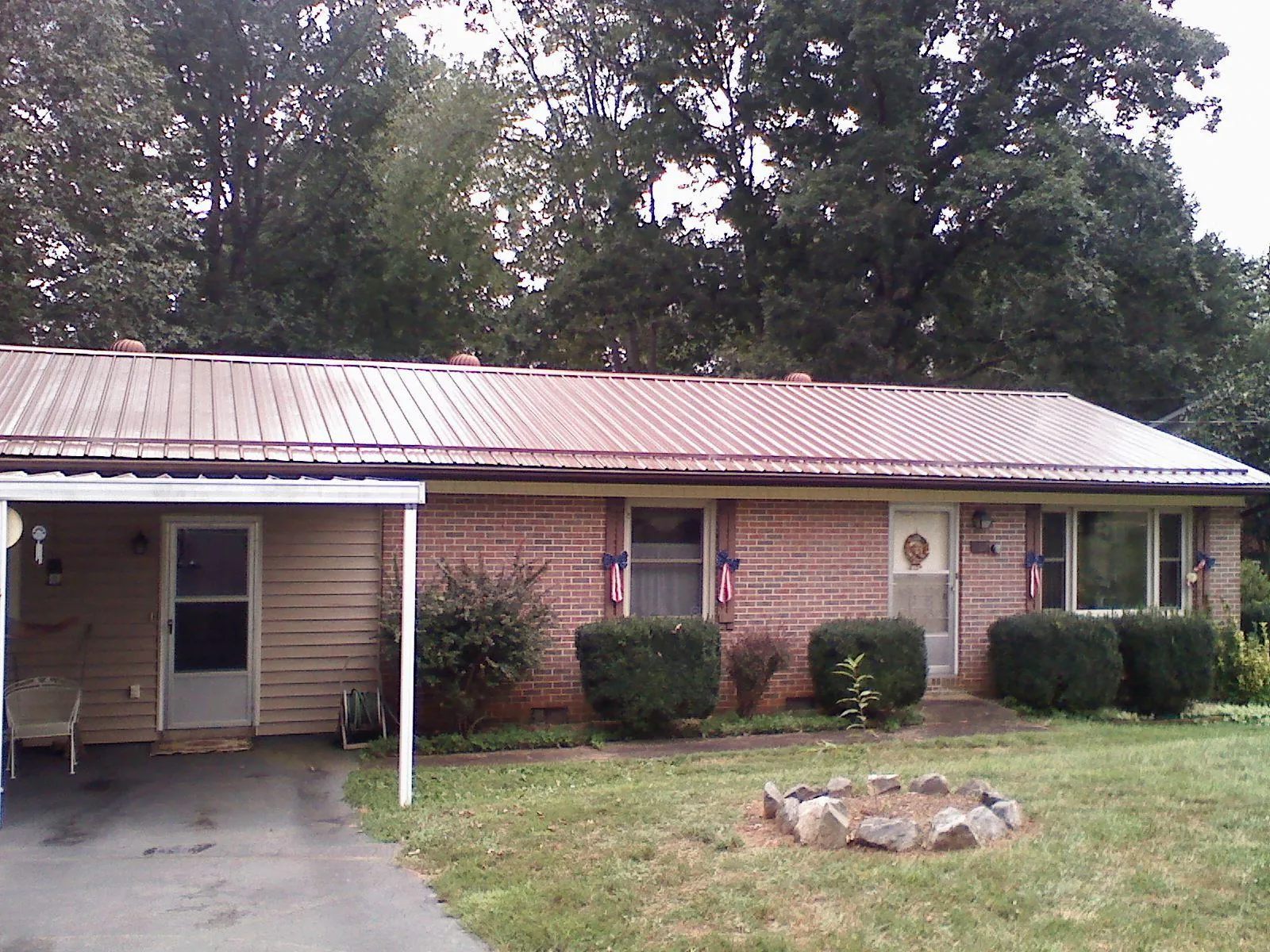 Bronze metal roof and carport on a brick ranch home — Roof Repair work by our crew in Evangeline
